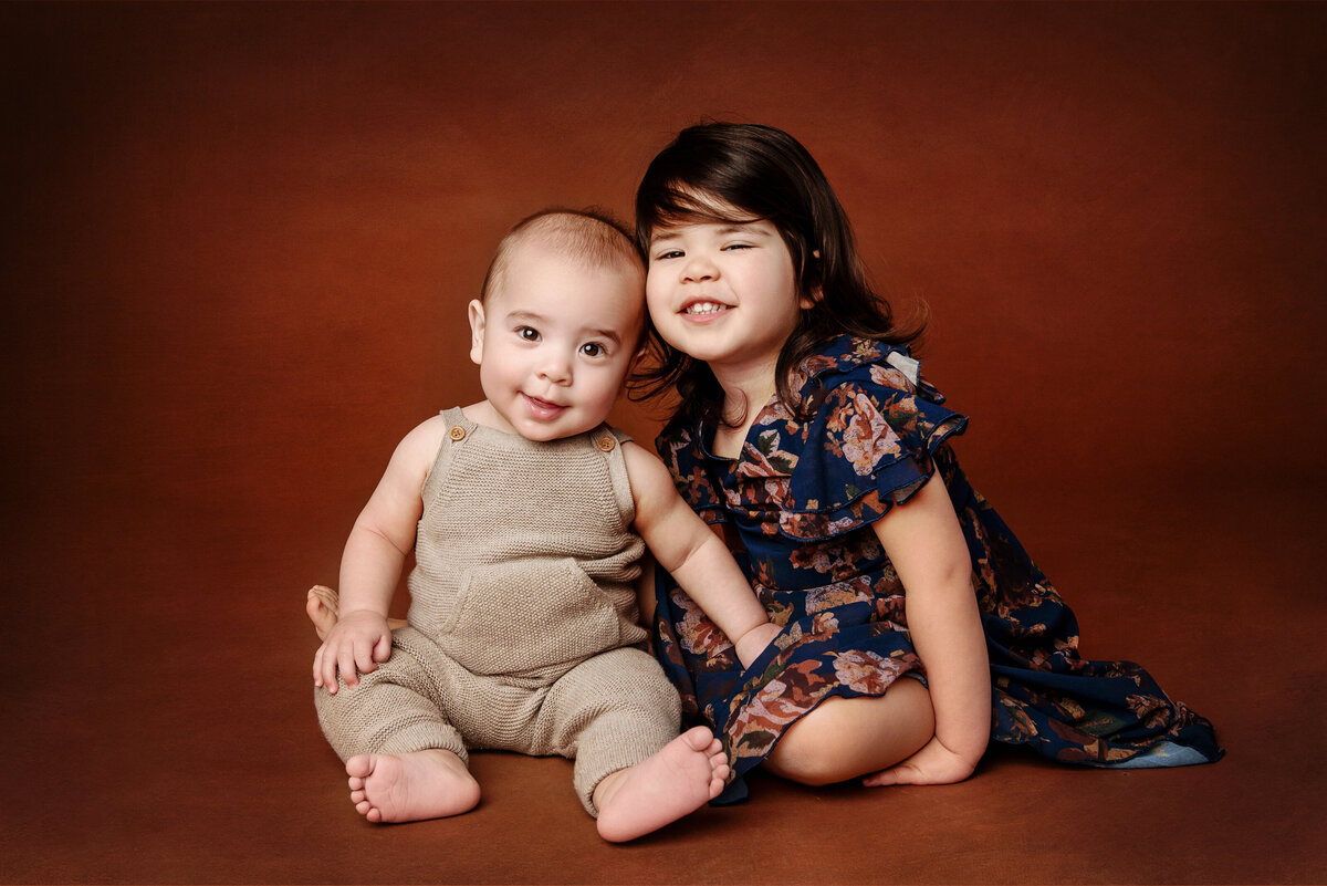 st-louis-family-photographer-brother-and-sister-sitting-on-brown-backdrop
