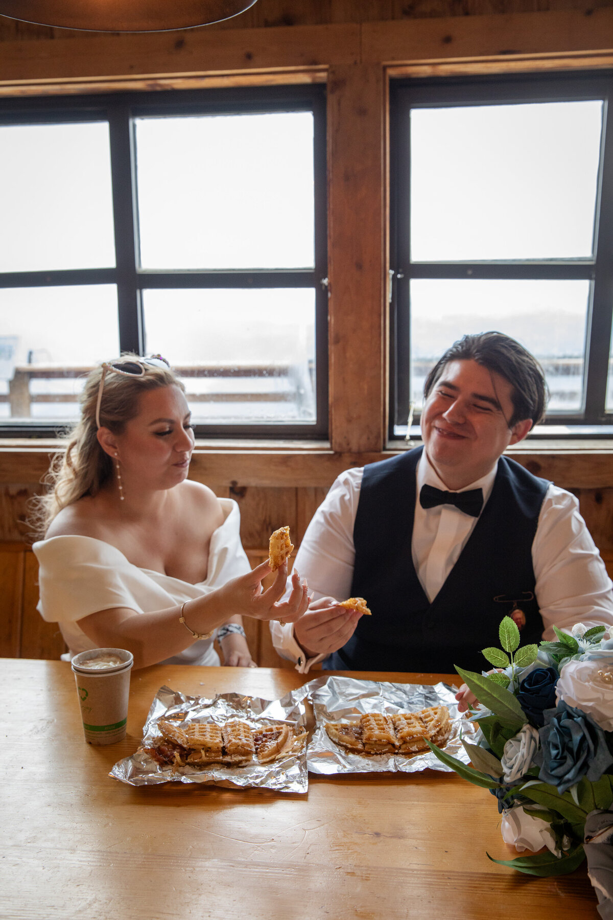 A bride and groom eat waffles on their elopement day in Wyoming.