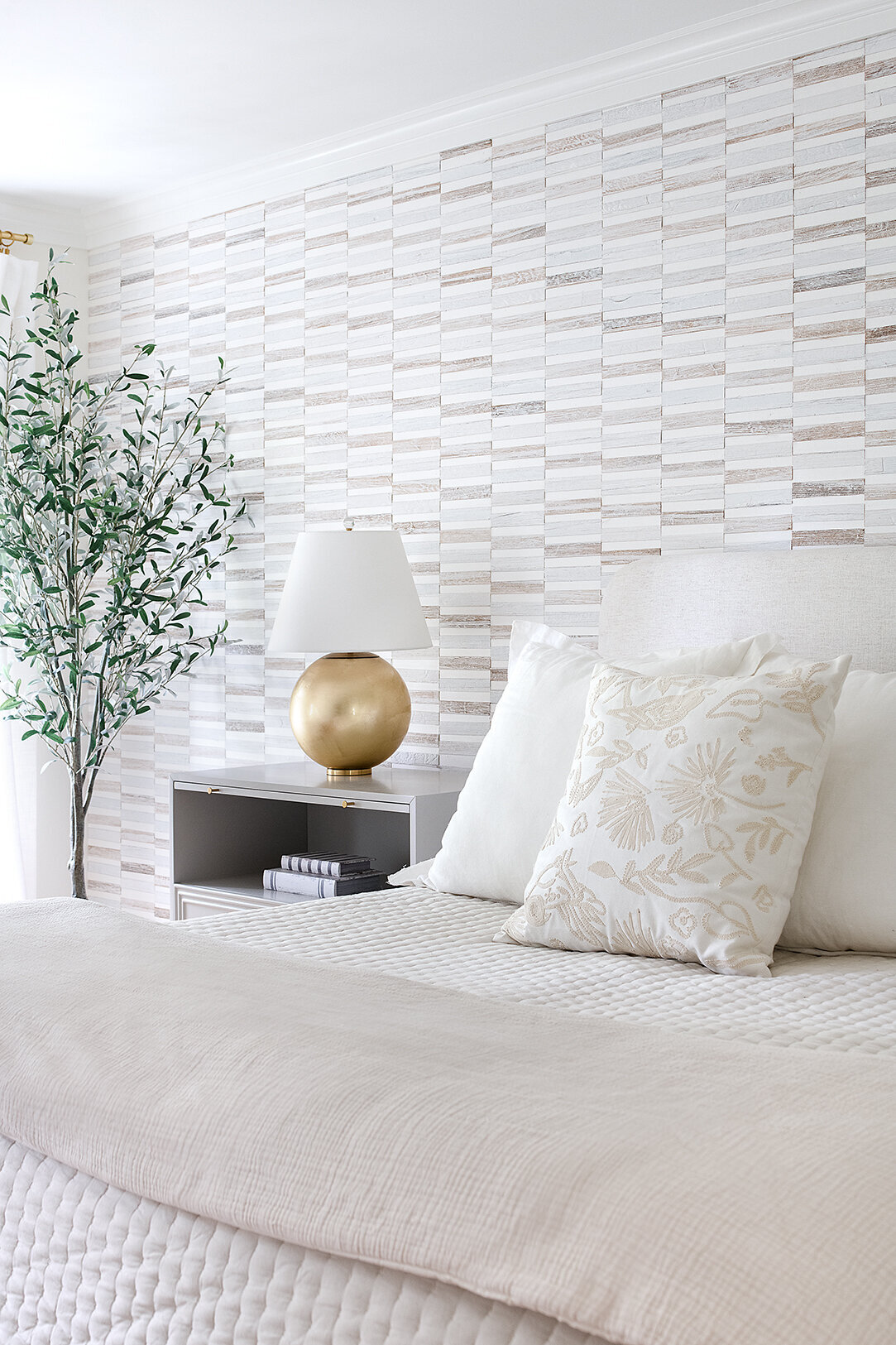 white bed with gold lamp and patterned walls