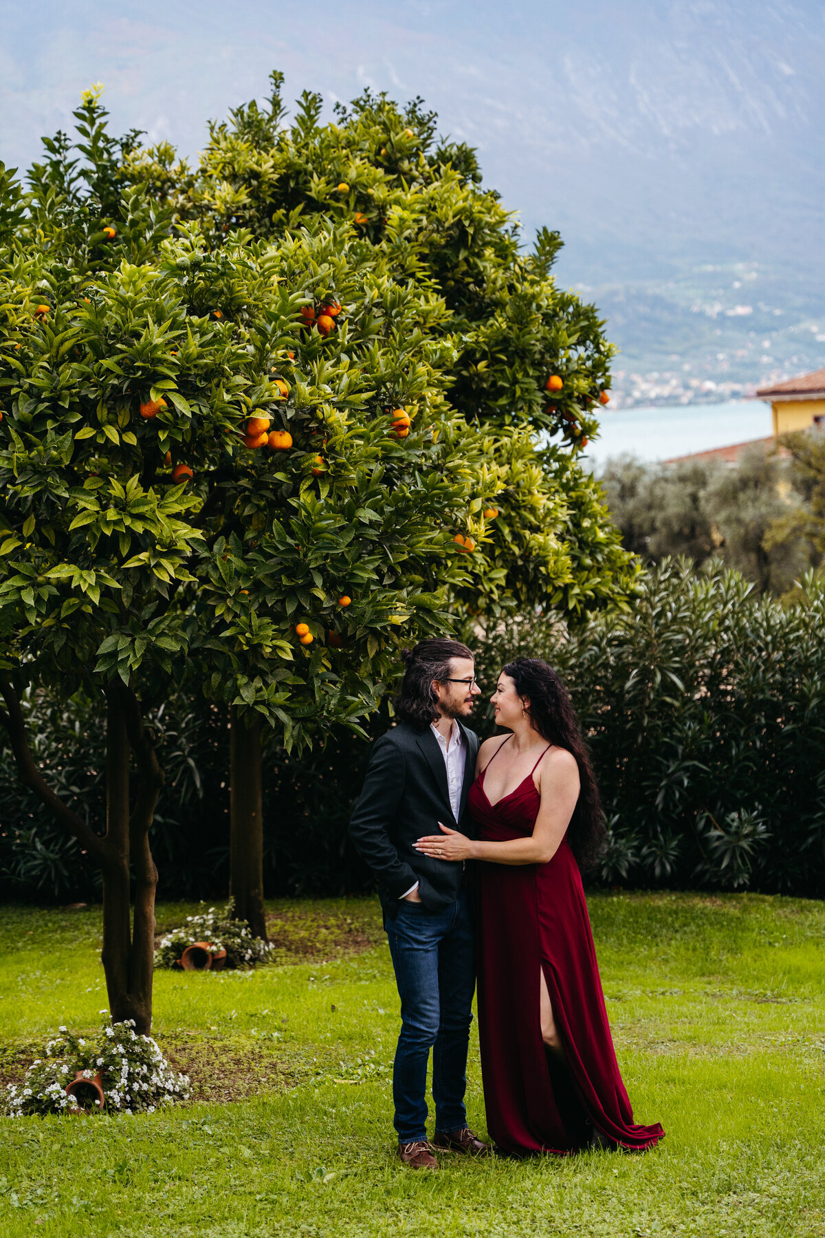 Couple standing together under orange tree in Lake Garda garden