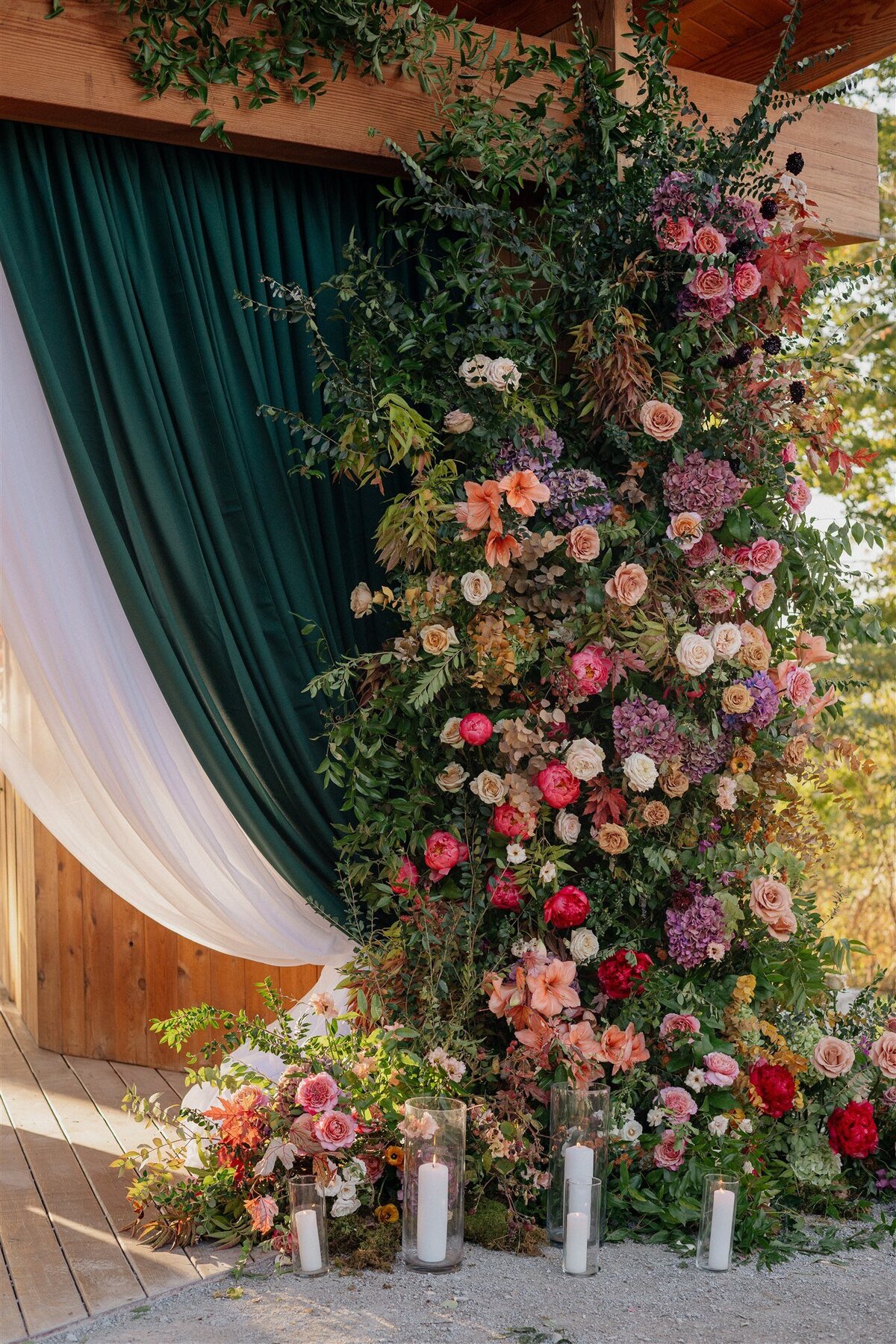 luxury wedding entrance with green velvet draping and covered in flowers