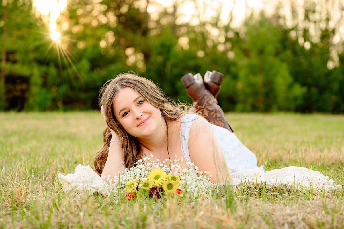 cuthbertson high school graduate leans against a wall wearing a green crop top with jeans