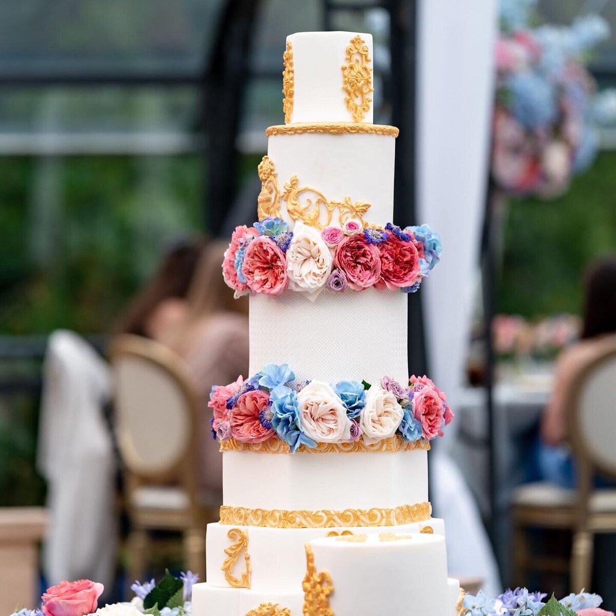White and gold wedding cake with fresh flowers