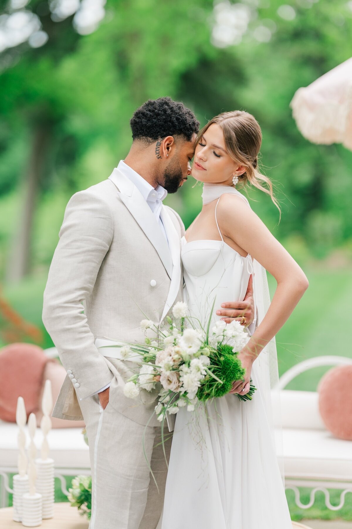 A man snuggling up against his bride on the outside patio at Glen Manor House. 
