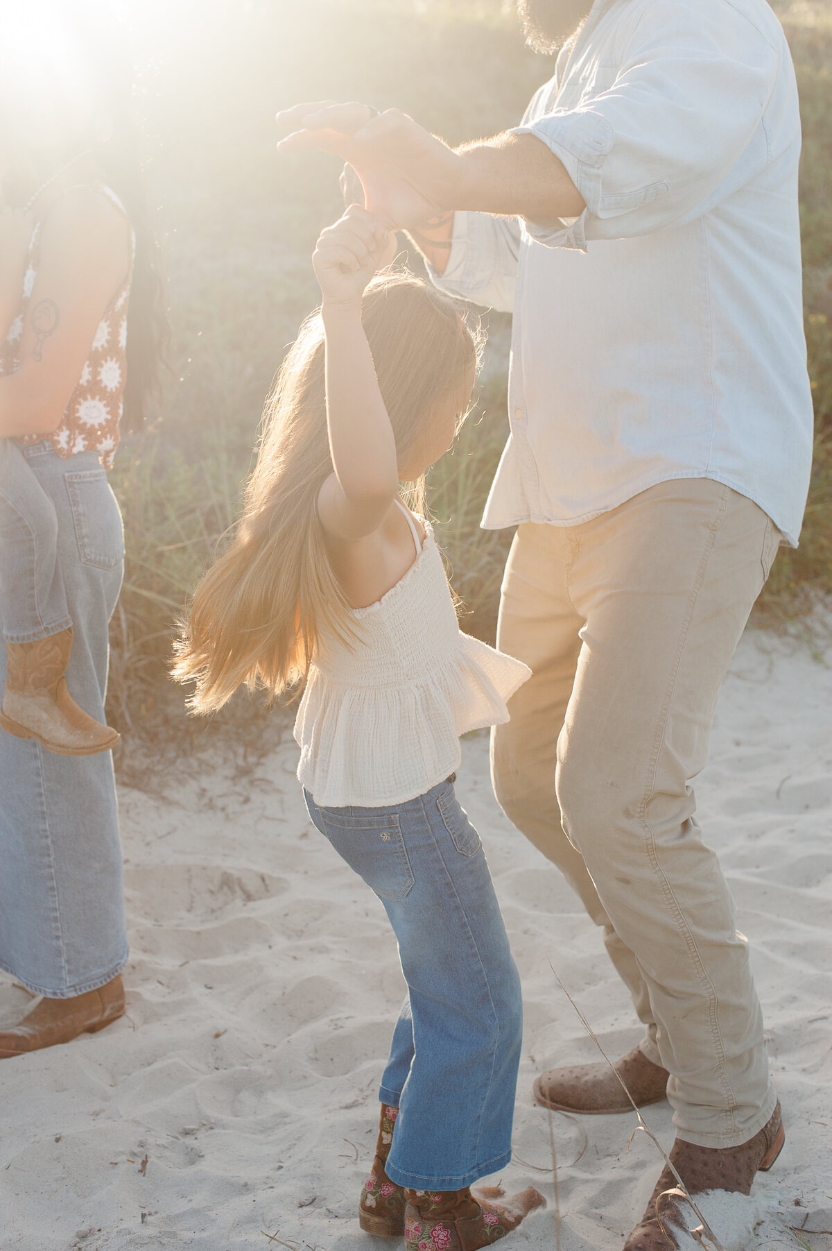 Daughter and daddy dancing on the beach in the dunes
