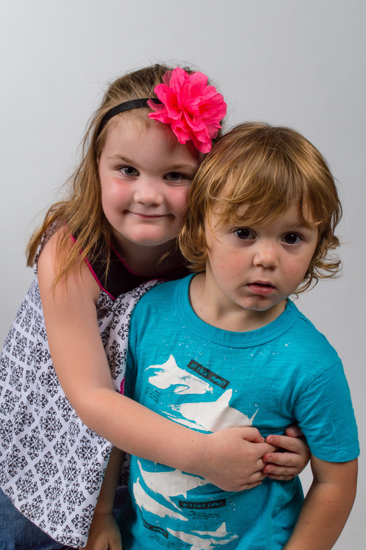 Siblings hug during their studio photography session