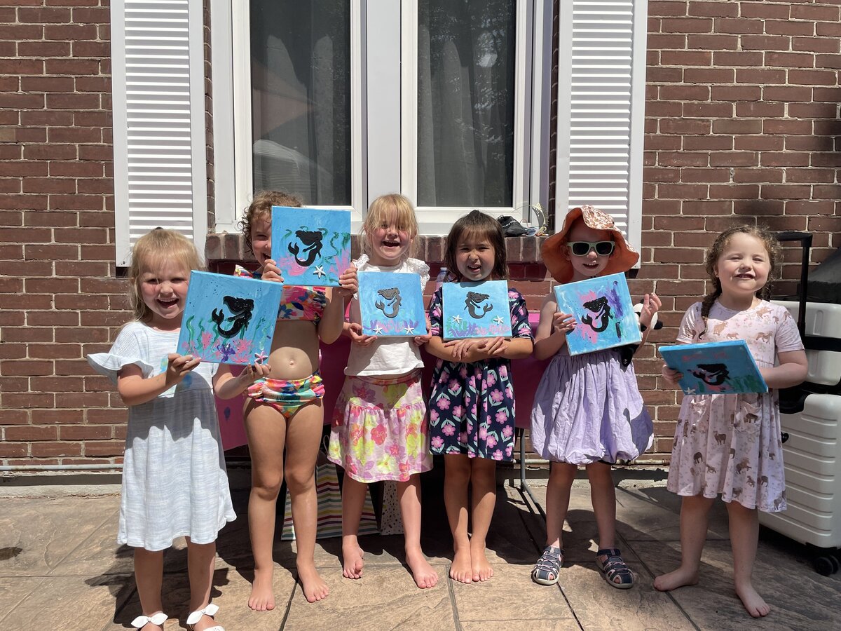 Completed mermaid paintings from a kids’ birthday party art session with Young at Art