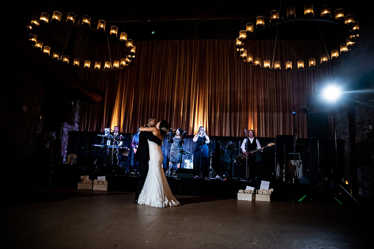 San Francisco Bay Area wedding photographer documents intimate first dance with live band performance and dramatic circular lighting on indoor stage at Estate Yountville in Napa Valley