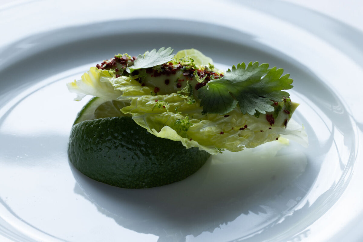 Romaine lettuce on lime wedge with spices and cilantro