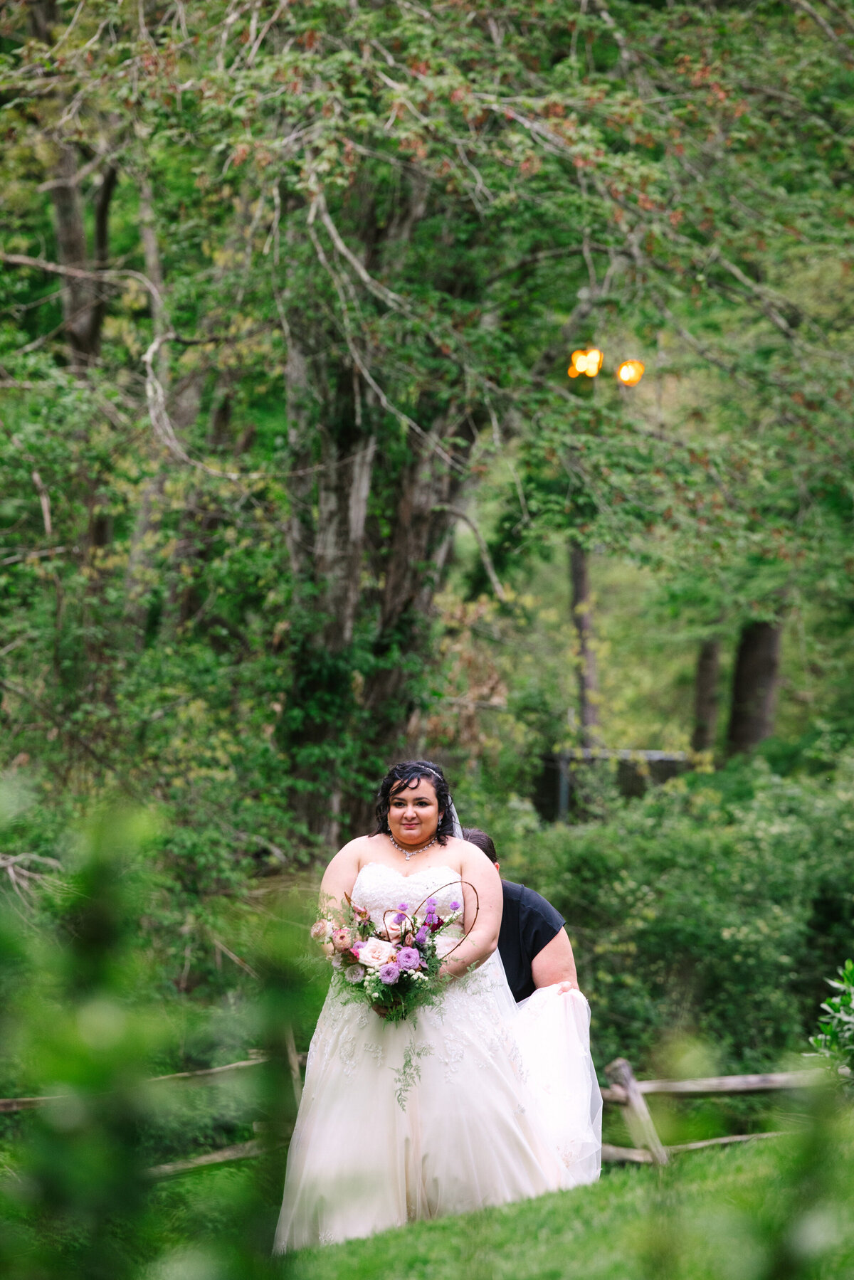 Bride getting her dress adjusted by Rachel