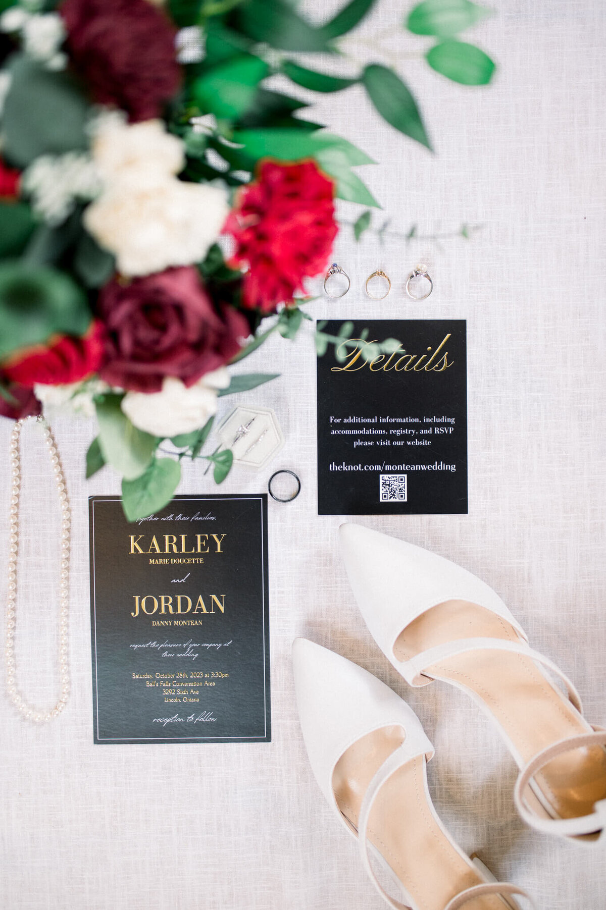 Wedding detail shot of flowers with invitations, shoes and rings. Captured by Niagara wedding photographer.