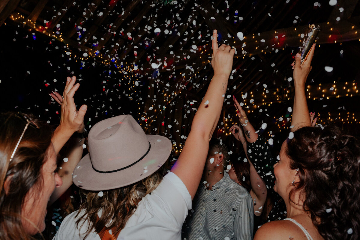 A packed dancefloor with silver confetti falling