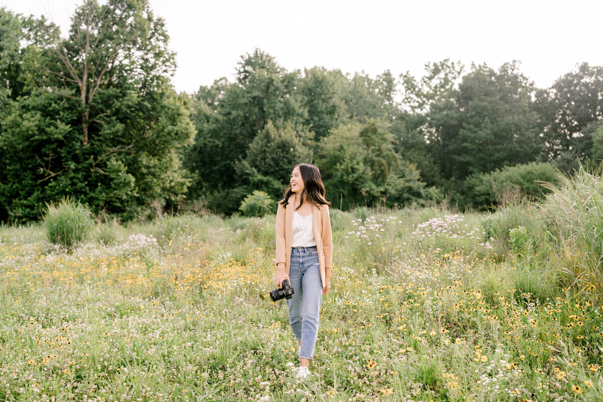 girl walking through a flower field with her camera