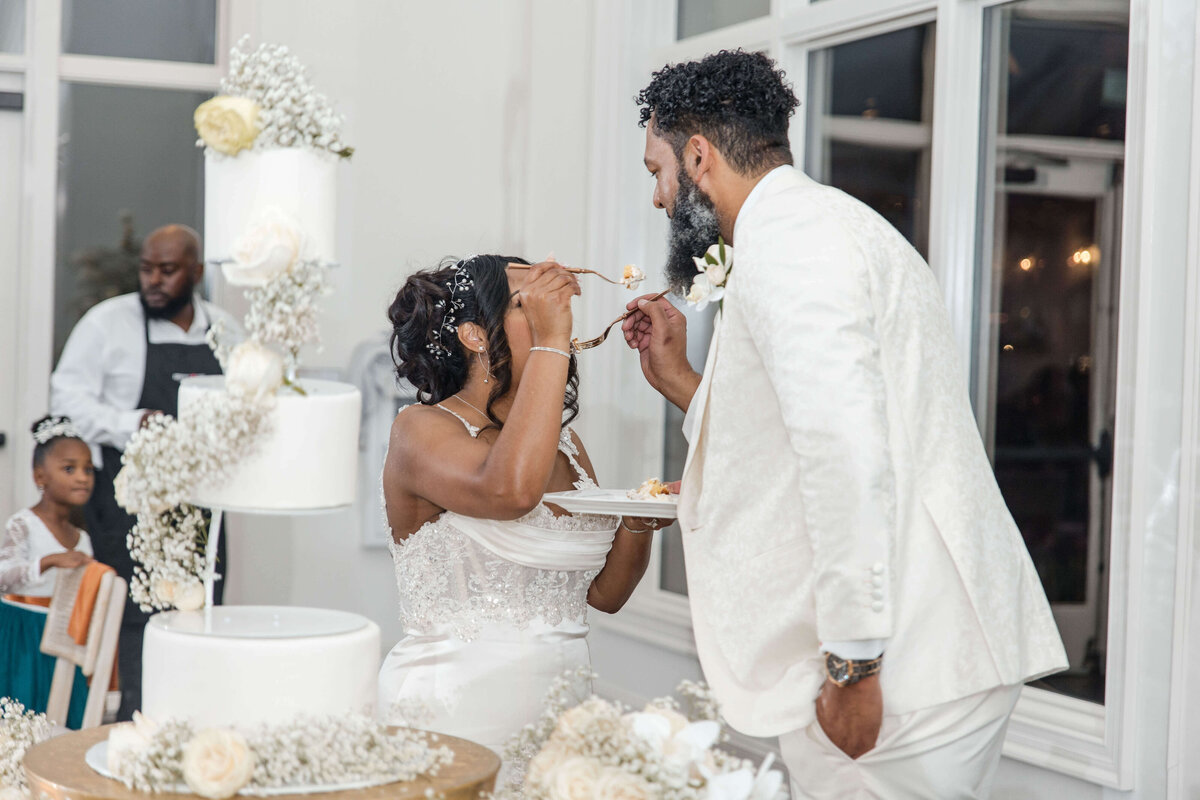 The newlyweds share a sweet moment as they cut into their elegant wedding cake.