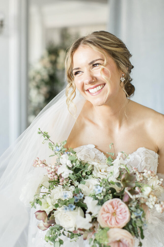 bride smiling with her wedding day bouquet