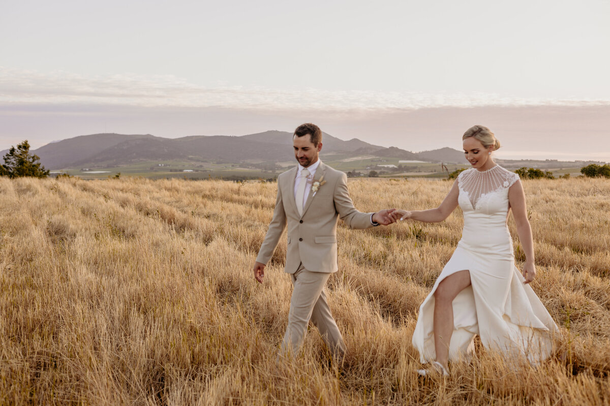 Hochzeitspaar mit Blick auf Berge und Felder in Südafrika