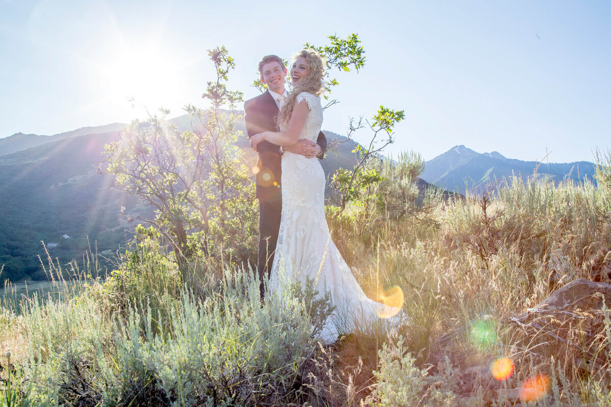 a wedding couple in sun flare on a mountain