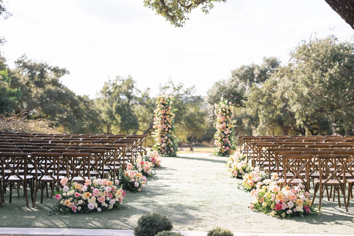 Romantic outdoor wedding ceremony setup with pastel wedding floral arrangements and garden-inspired aisle decor in Central Texas.