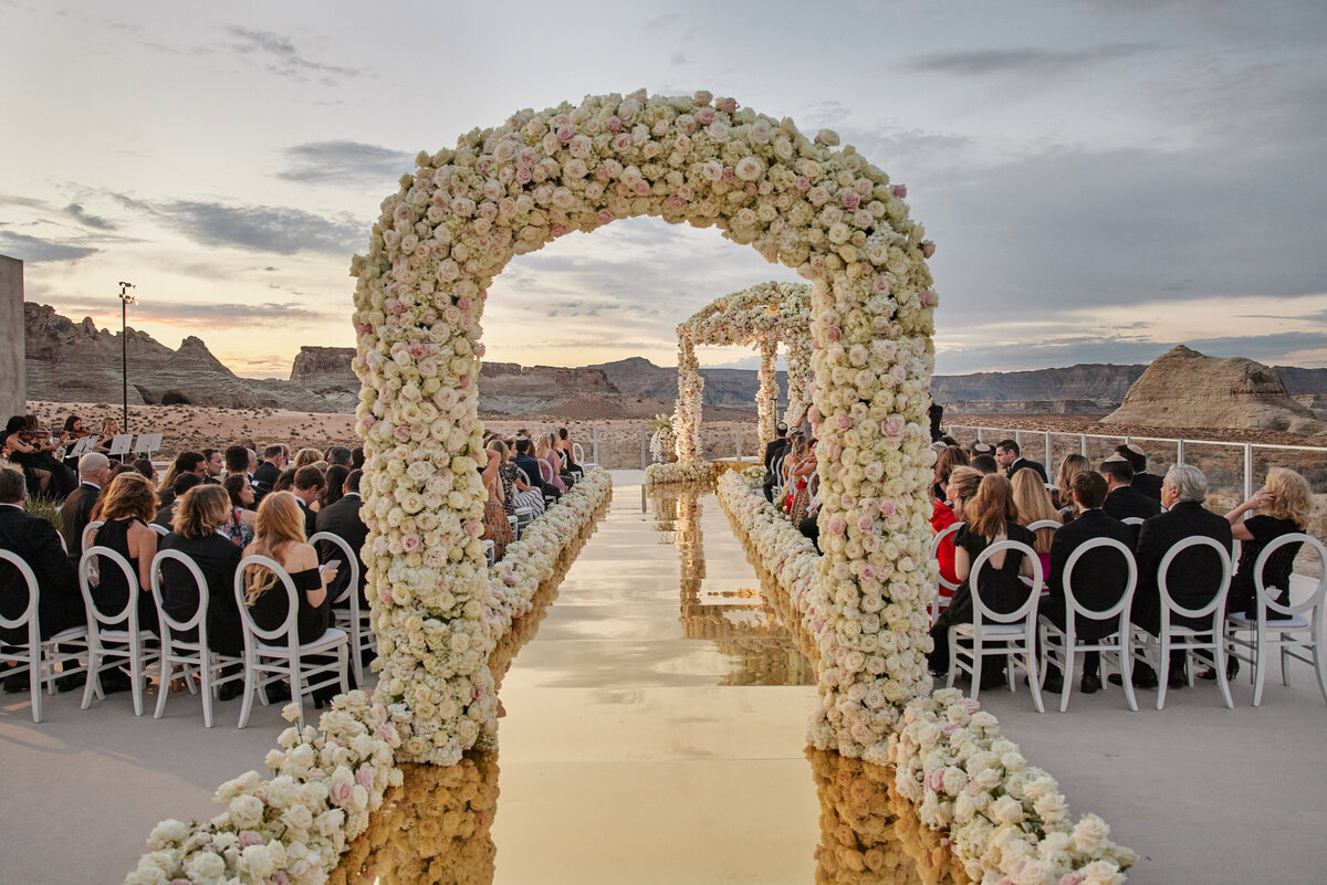 Chuppah at amangiri Utah with golden aisle and white flowers and chairs