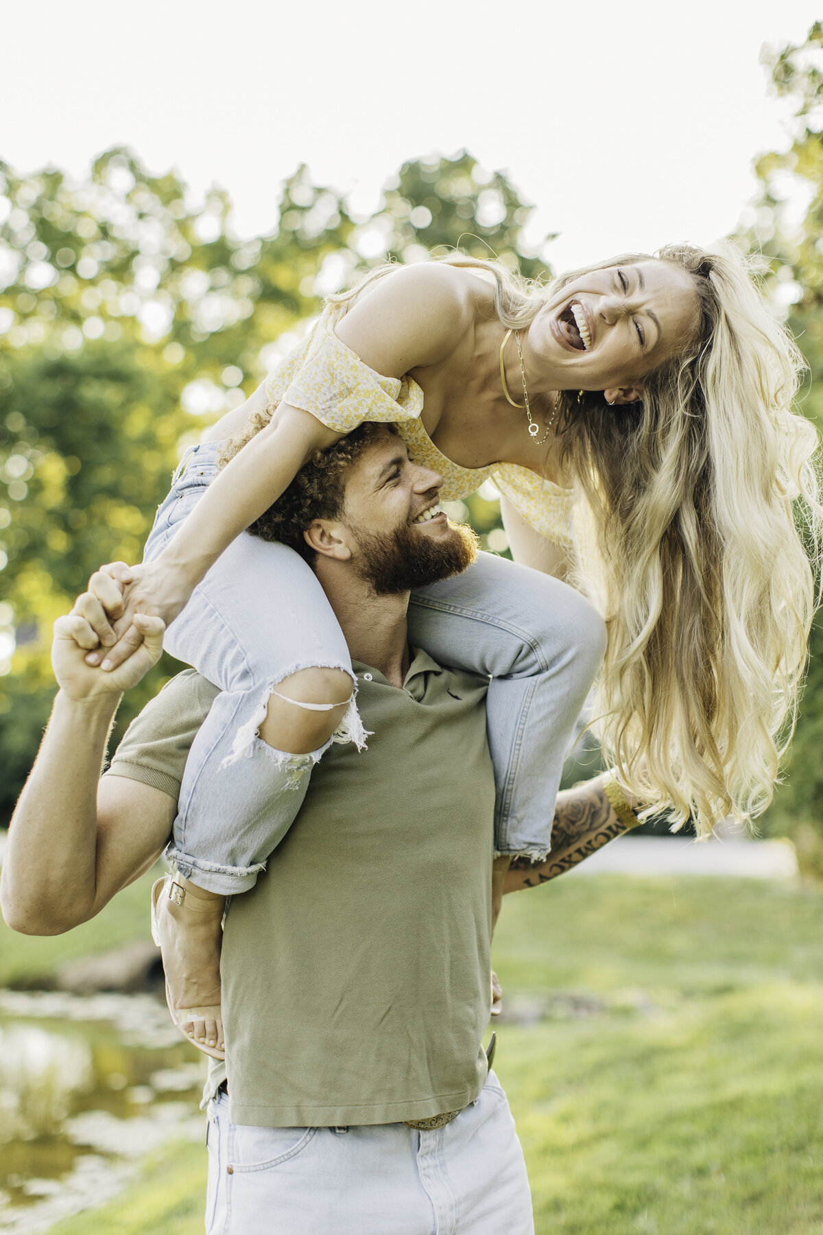 Man grinning as girlfriend sits on his shoulders