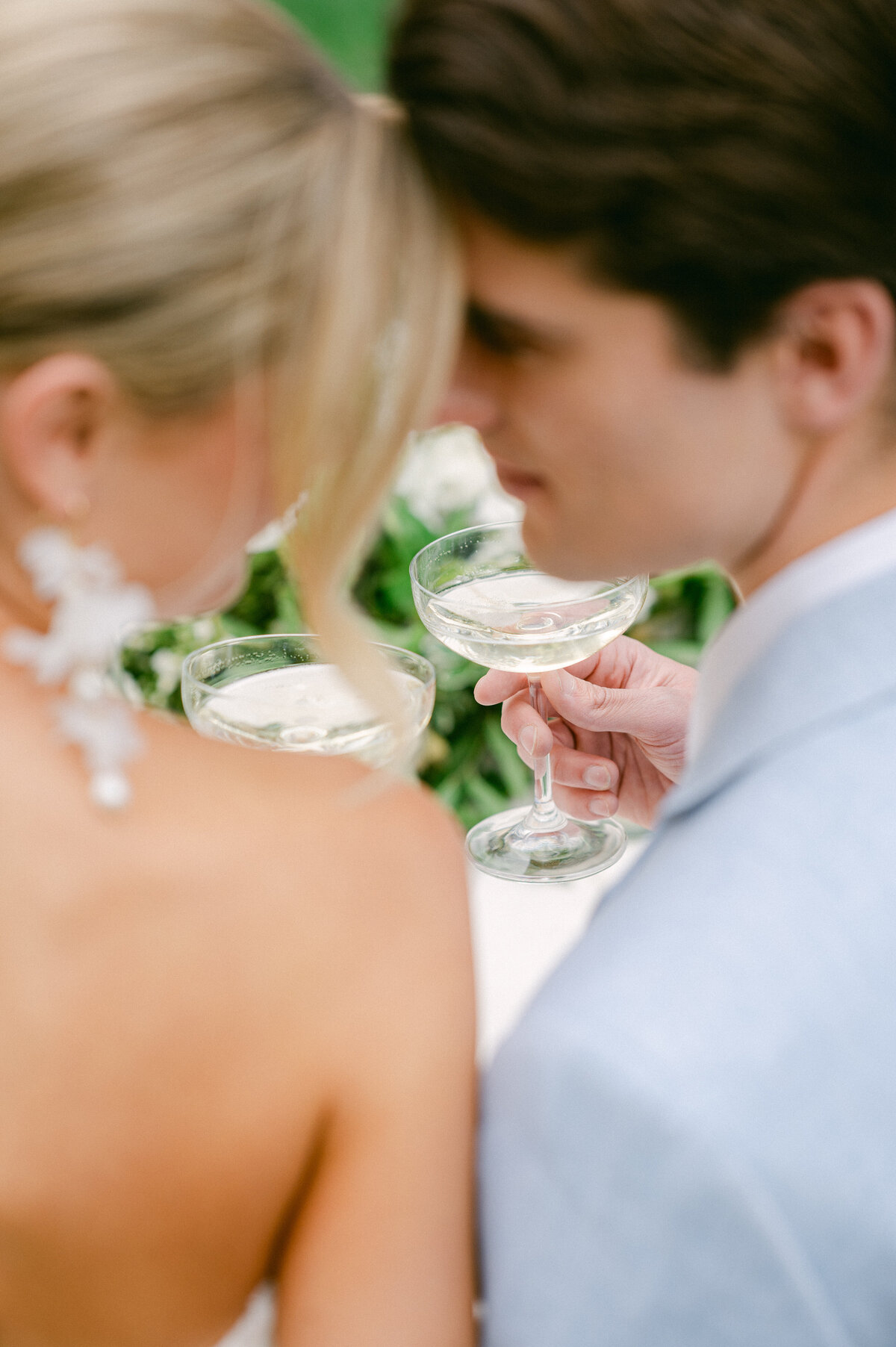 Bride and Groom lean in and cheers during their wedding dinner.
