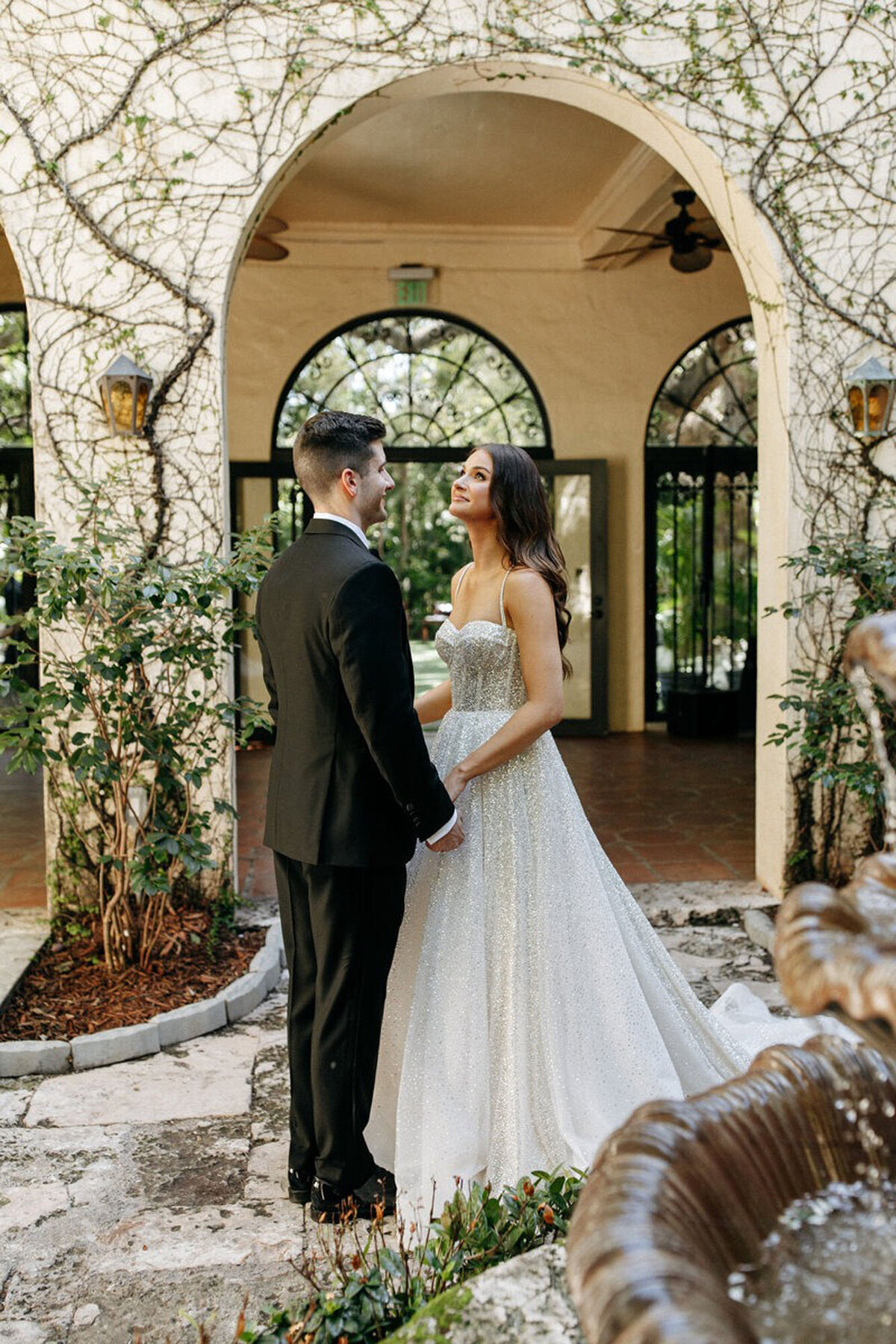 Bride and groom embracing in courtyard at venue, by wedding photographers in orlando fl
