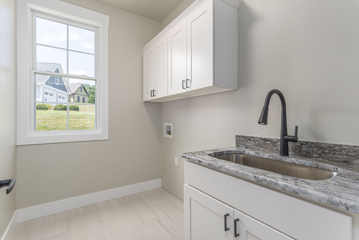 A laundry room with a sink and custom built ins