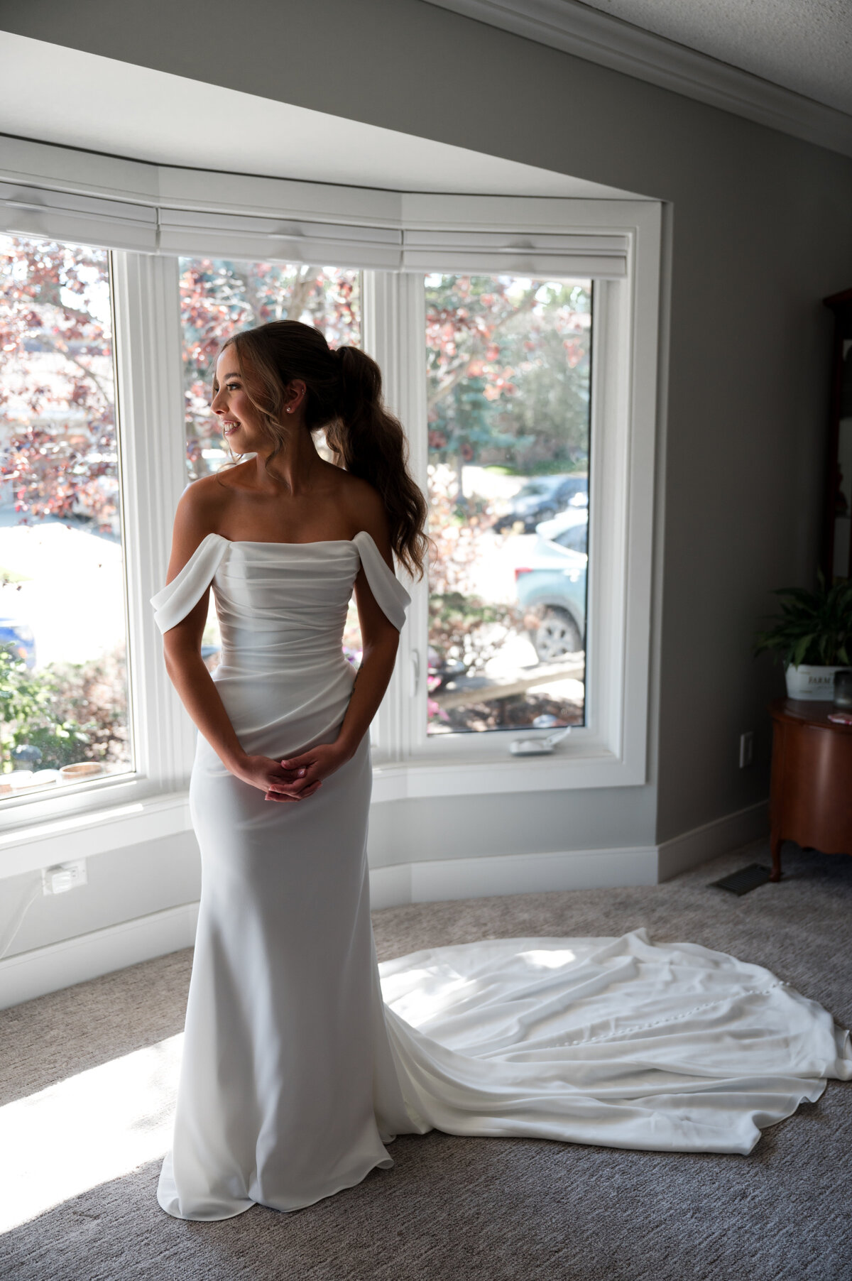 Edmonton bride standings in front of windows awating the wedding ceremony