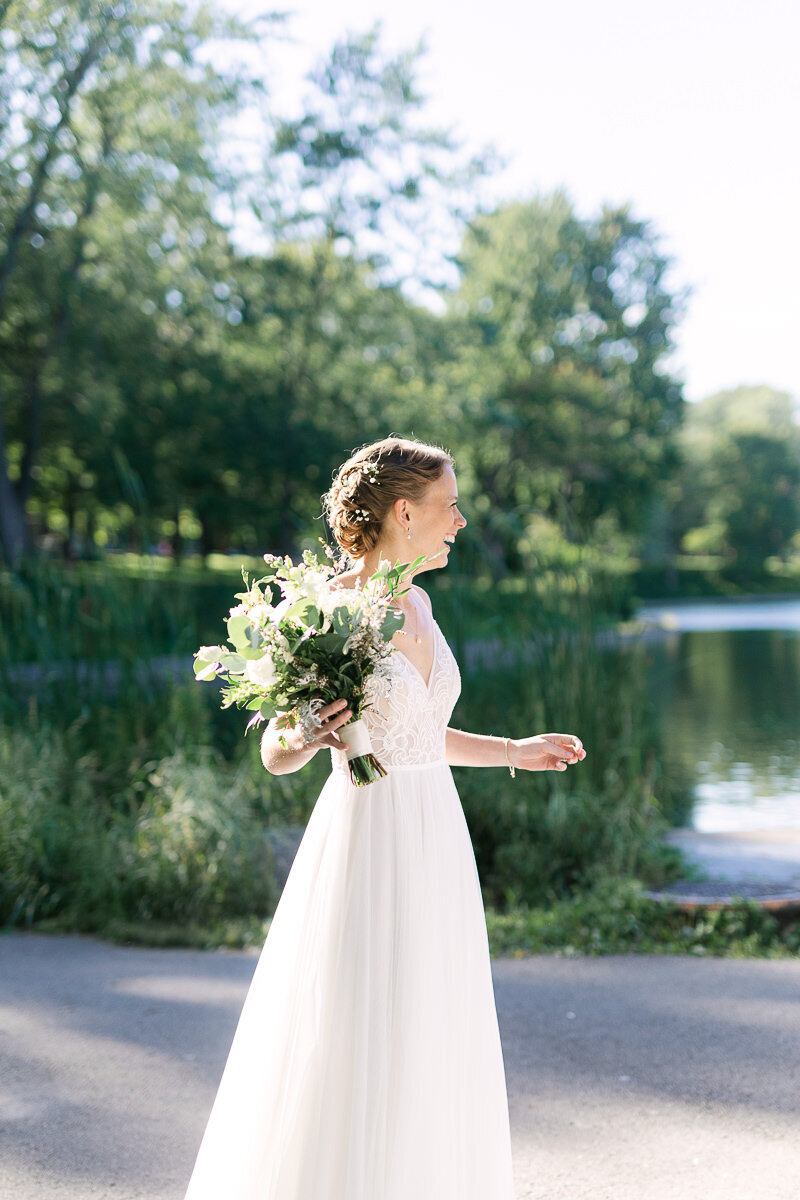 La mariée est heureuse et souriante et elle tient son bouquet de fleurs