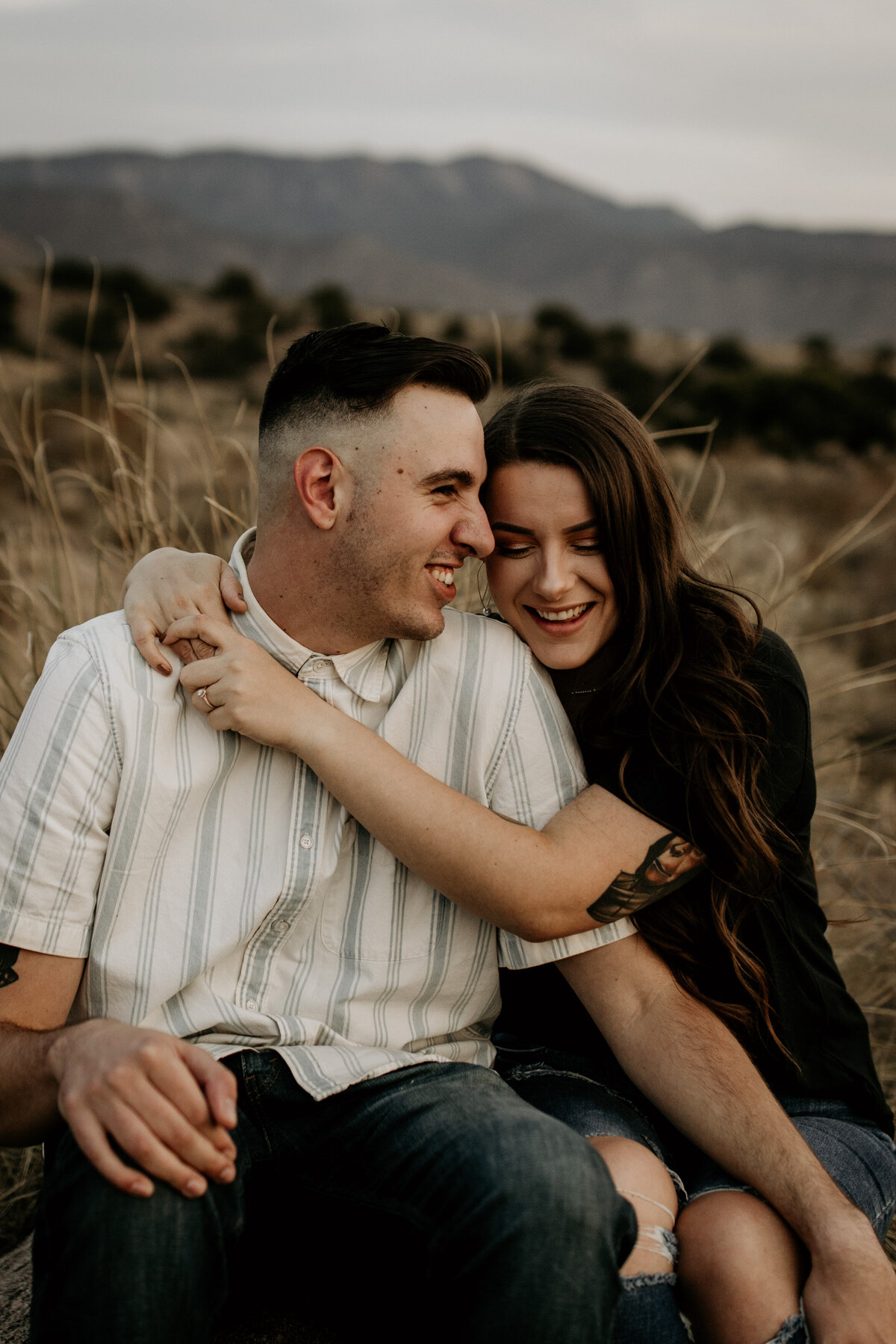 woman sitting with hugging fiancé in Albuquerque