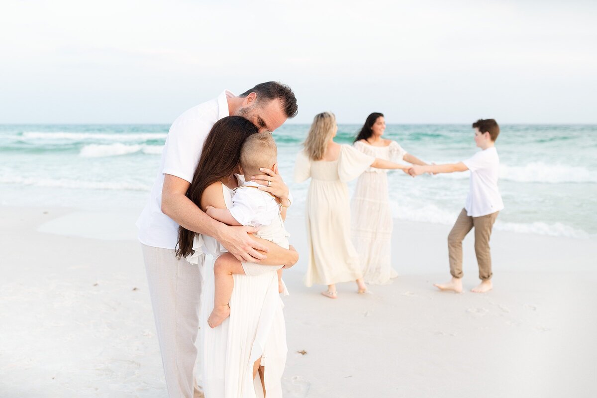 a couple on the beach enjoying their children during a family  photography session in Destin Florida