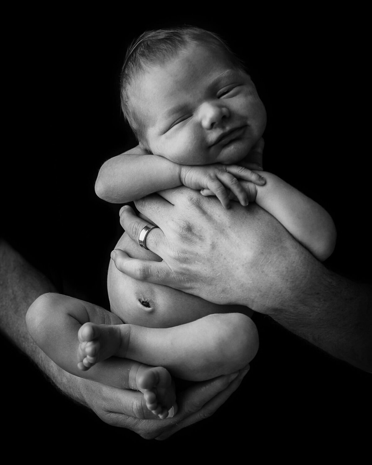 baby in dads hands in black and white