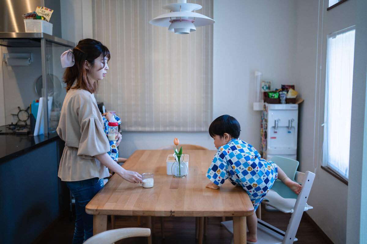 ダイニングテーブルの席に着こうとしている親子