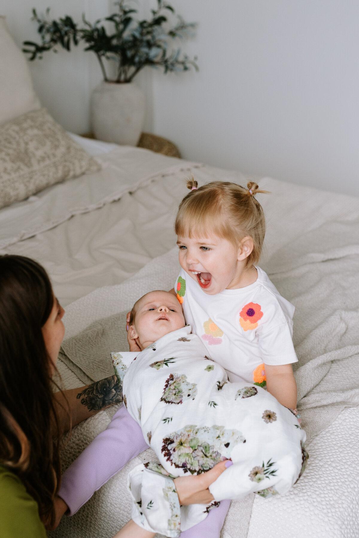 A young girl holds her new baby sister in Calgary, Alberta