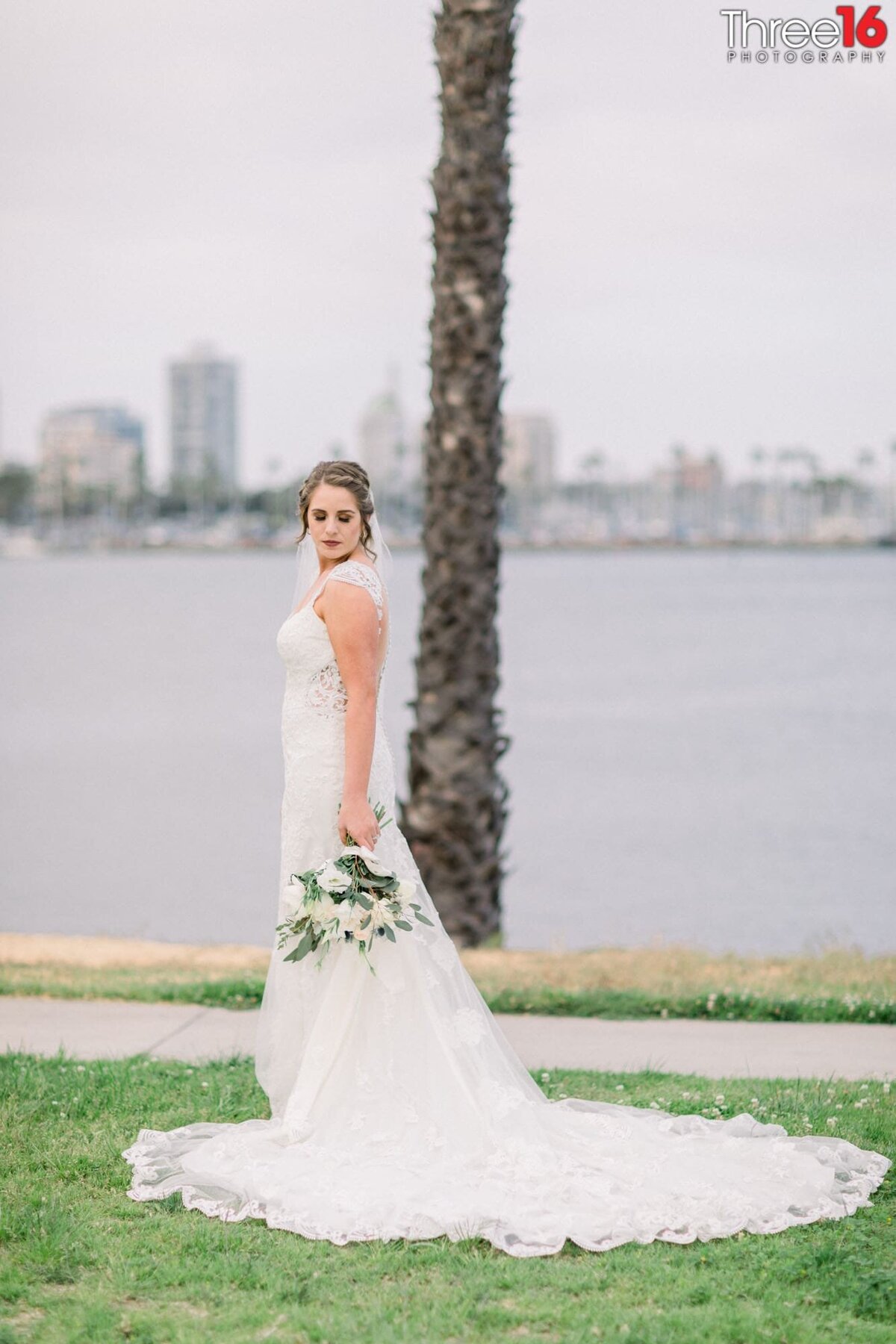 Bride poses by with her dress train fanned out next to the Long Beach Harbor