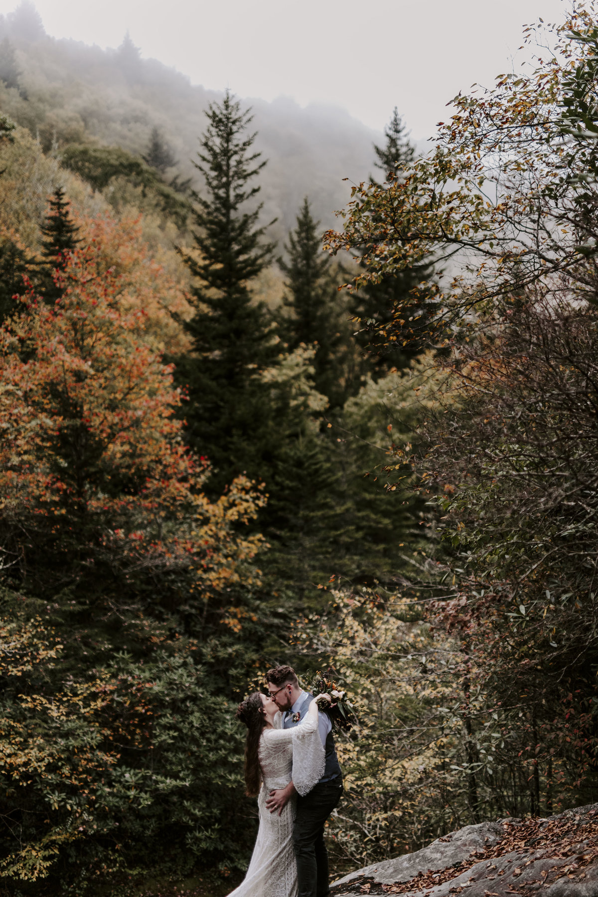 Couple kissing on top of a waterfall in Pisgah National Forest