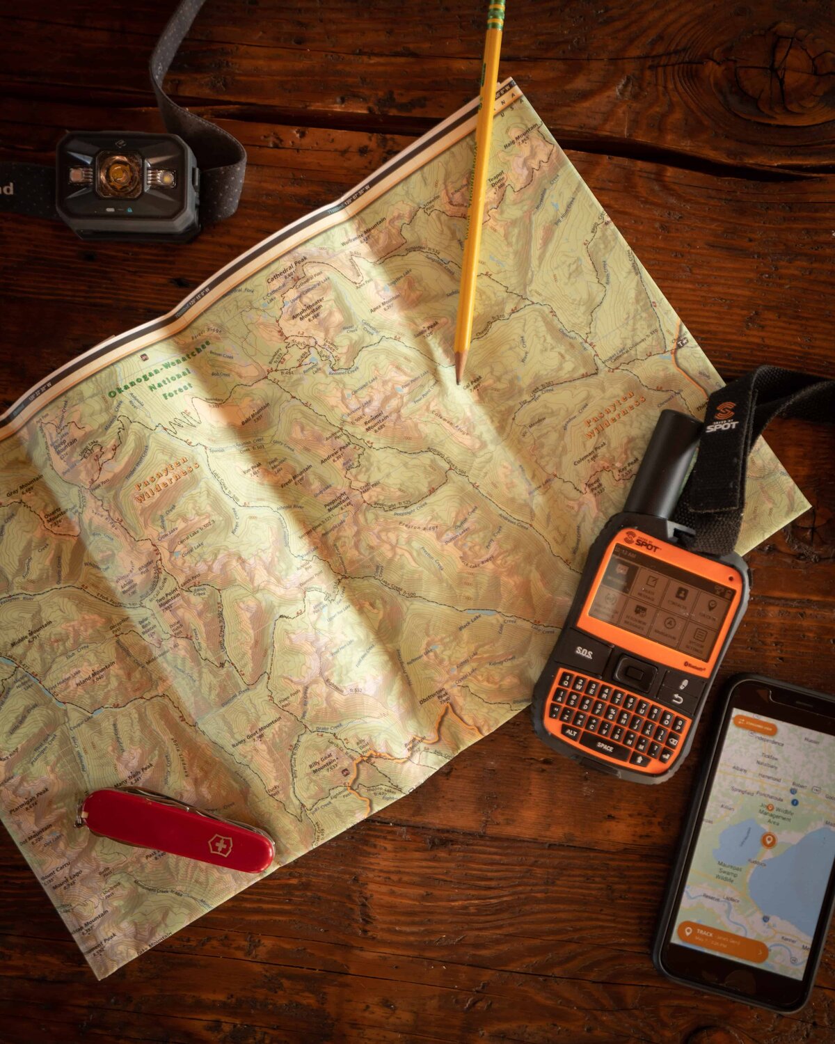 Orange SPOT GPS on a map on a wooden table