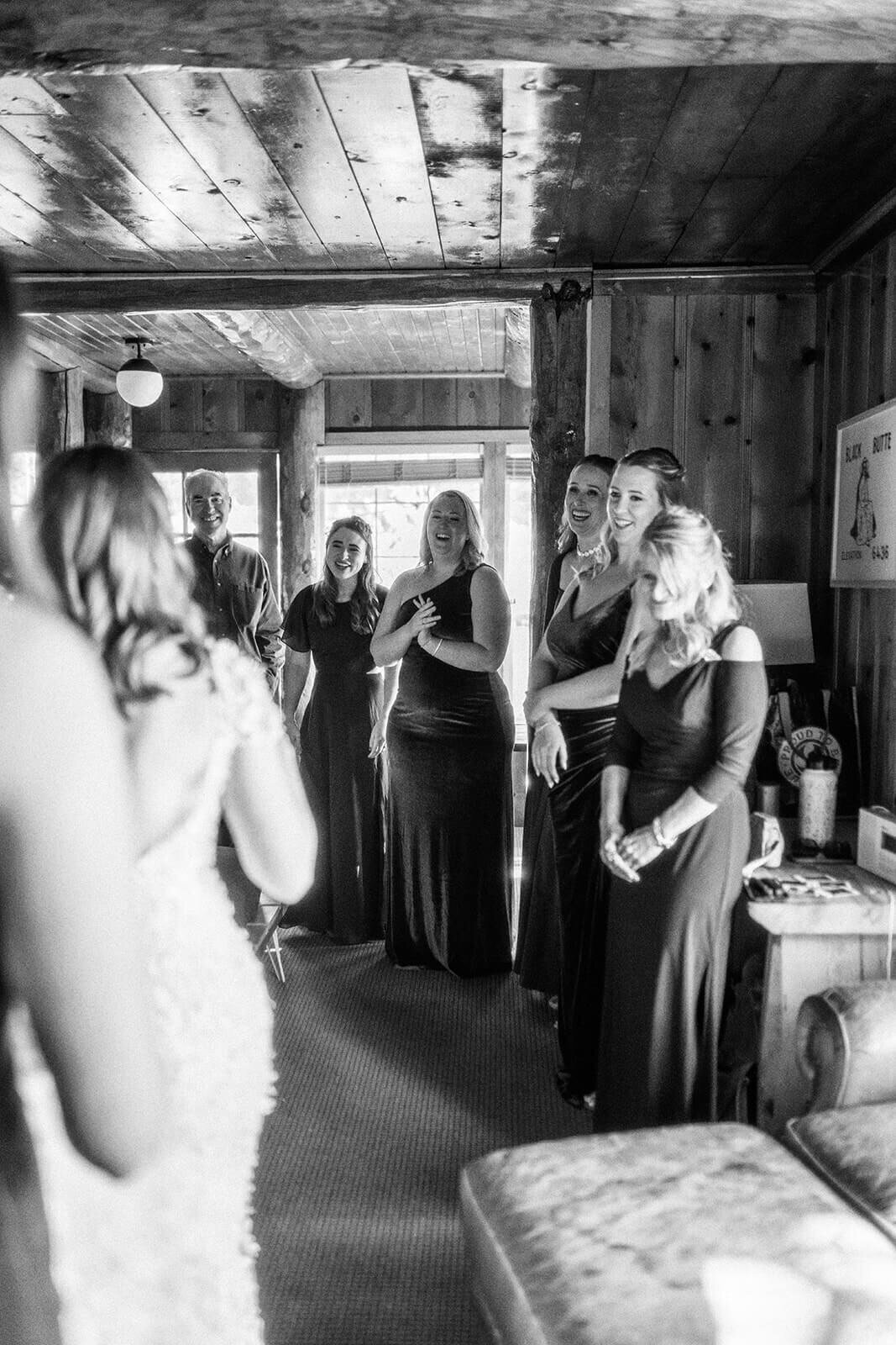 A group of people indoors smiling and laughing before a wedding.