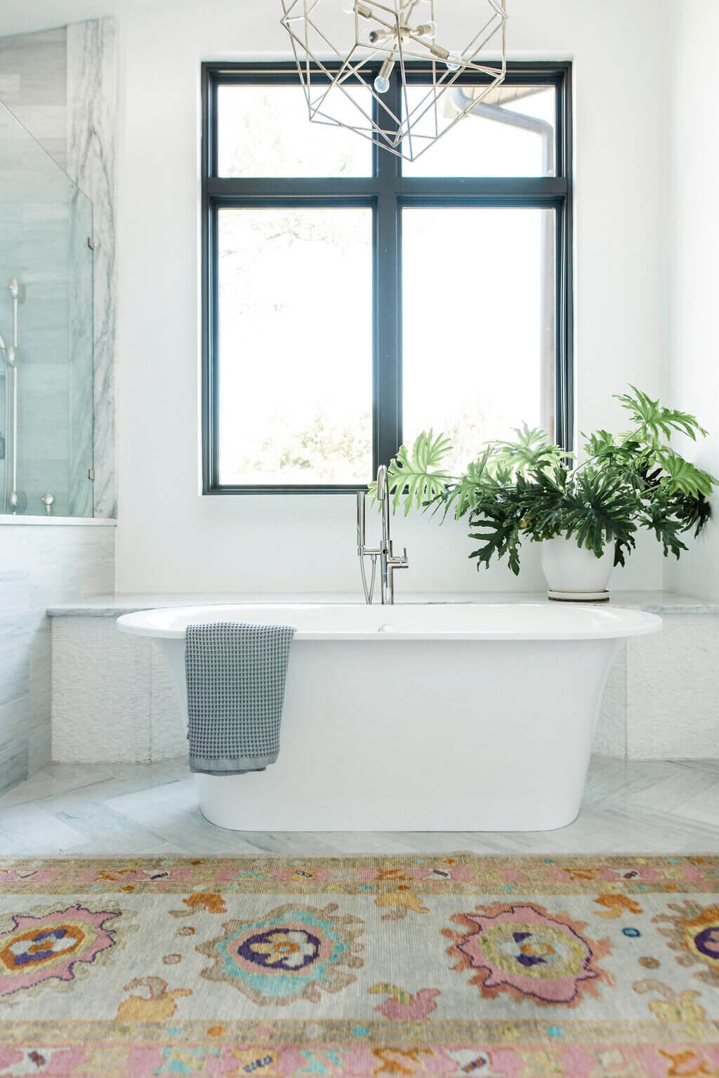 oyster creek studios austin barton creek free standing bathtub with gray towel and orange patterned rug in bathroom