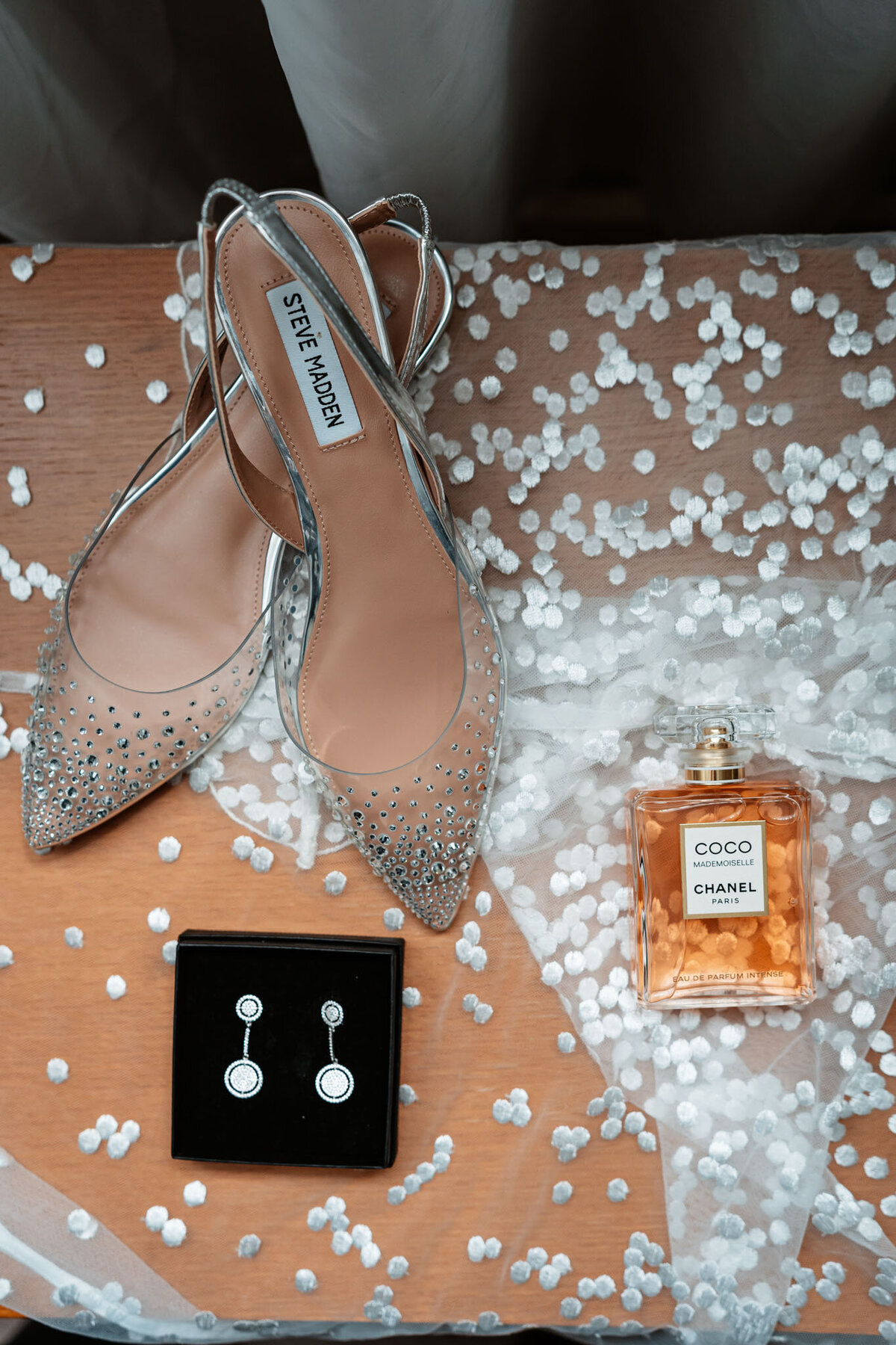 Emily's beautiful shoes and earrings being prepared for her wedding ceremony