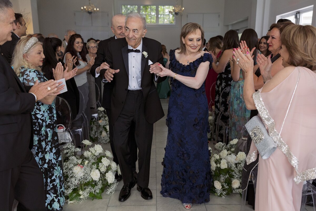 Parents walks down the aisle during indoor wedding ceremony at Belle Mer, Newport.