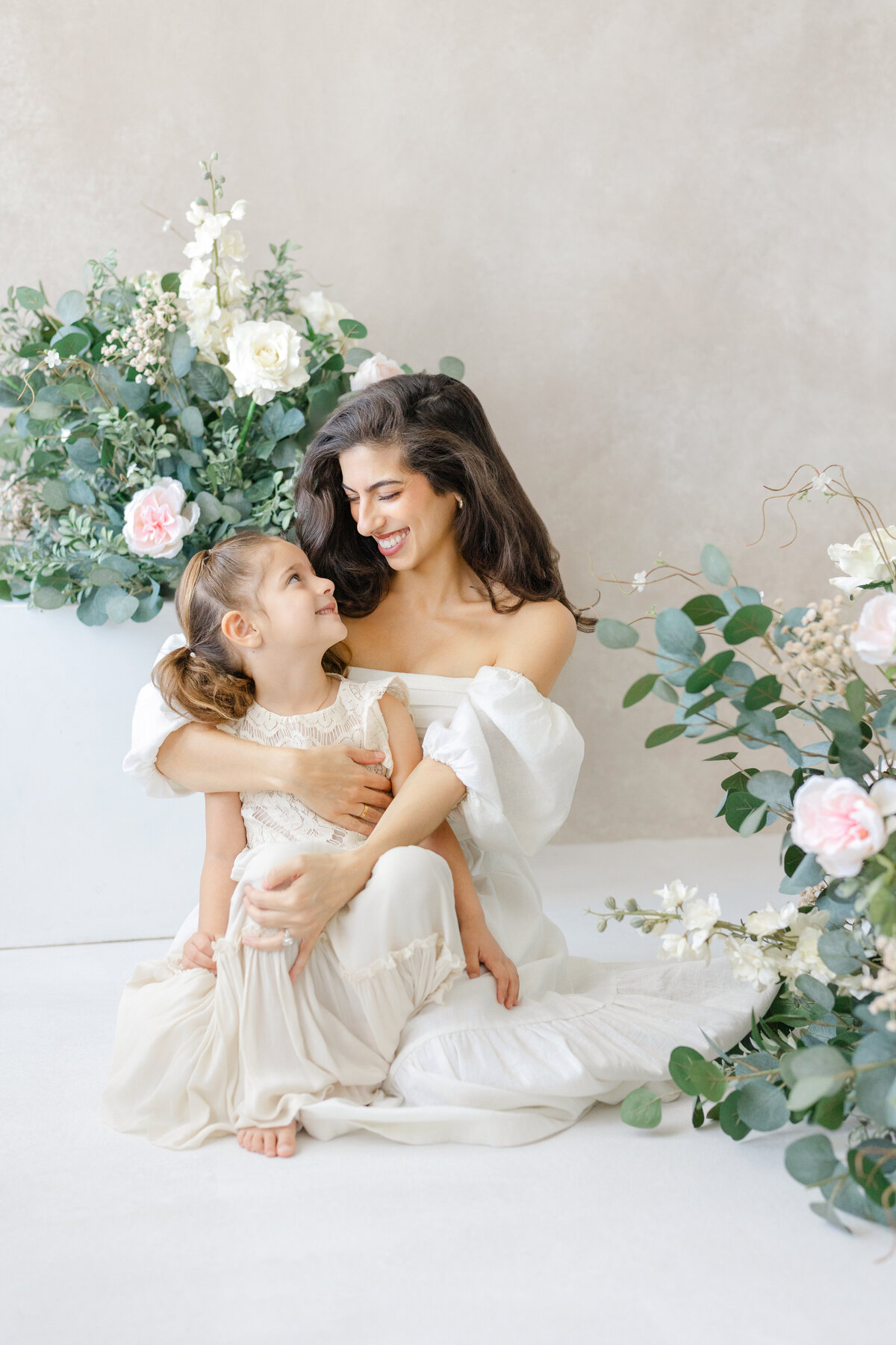 Joyful Tampa motherhood portrait of mom and daughter laughing together in soft natural light studio