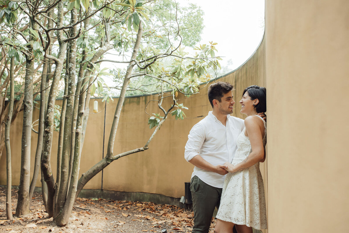 Couple by curved wall and unique tree during engagement shoot at Grounds for Sculpture in Hamilton Township Mercer County New Jersey