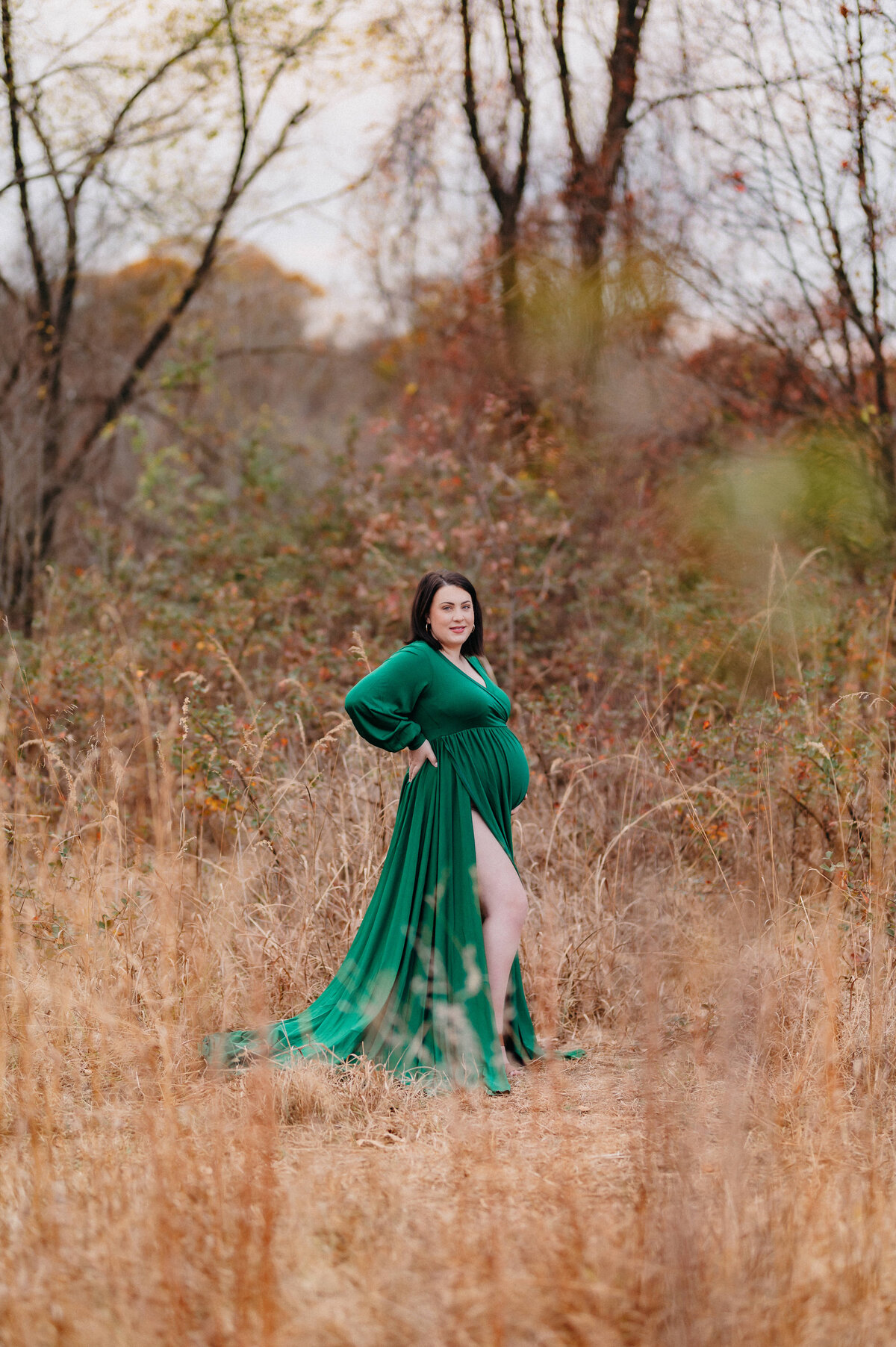 woman in flowin emerald green dress tall grass and soft light in Millersville, MD.