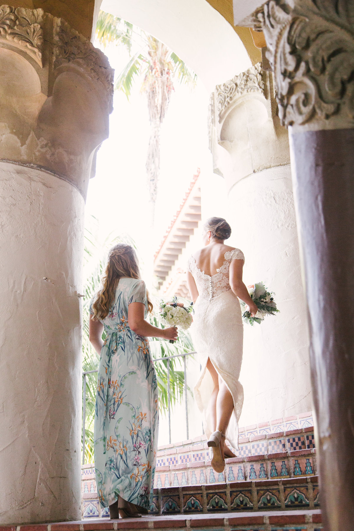 Bride and bridesmaid walk up stairs to Santa Barbara Courthouse wedding ceremony
