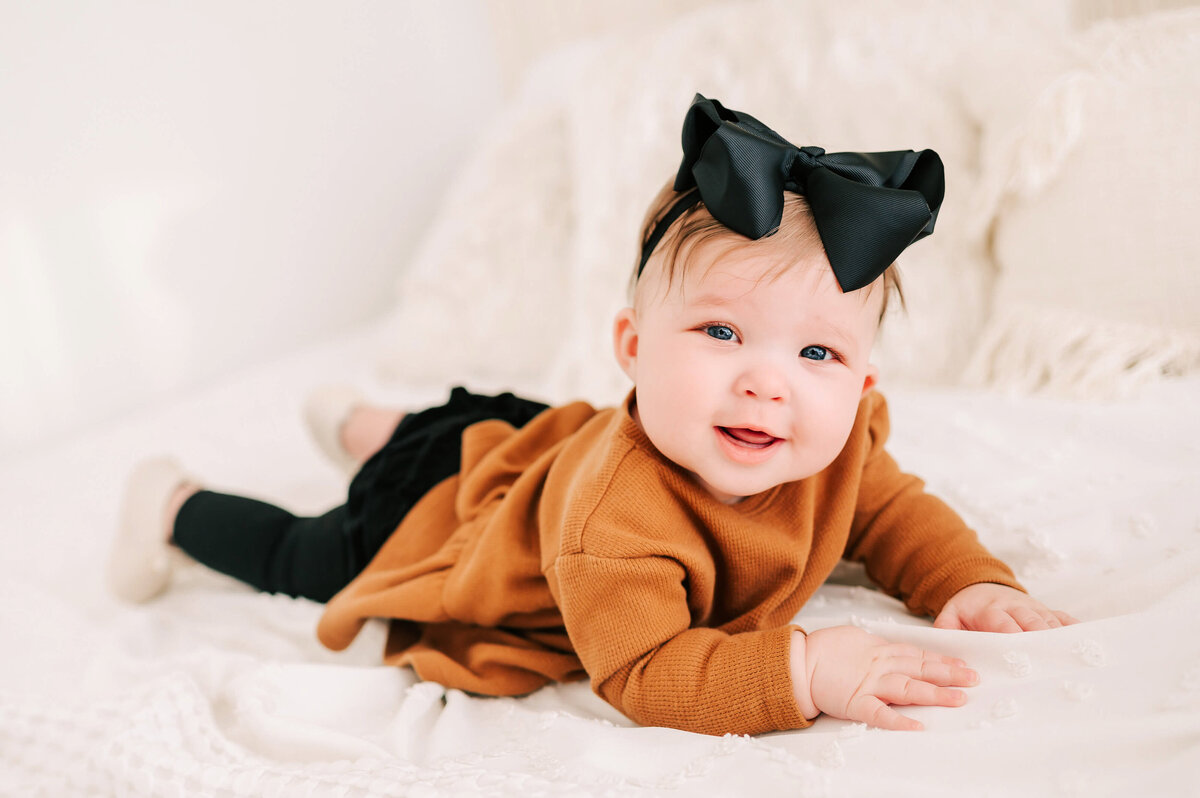 baby portrait in Branson Mo of little girl smiling on belly