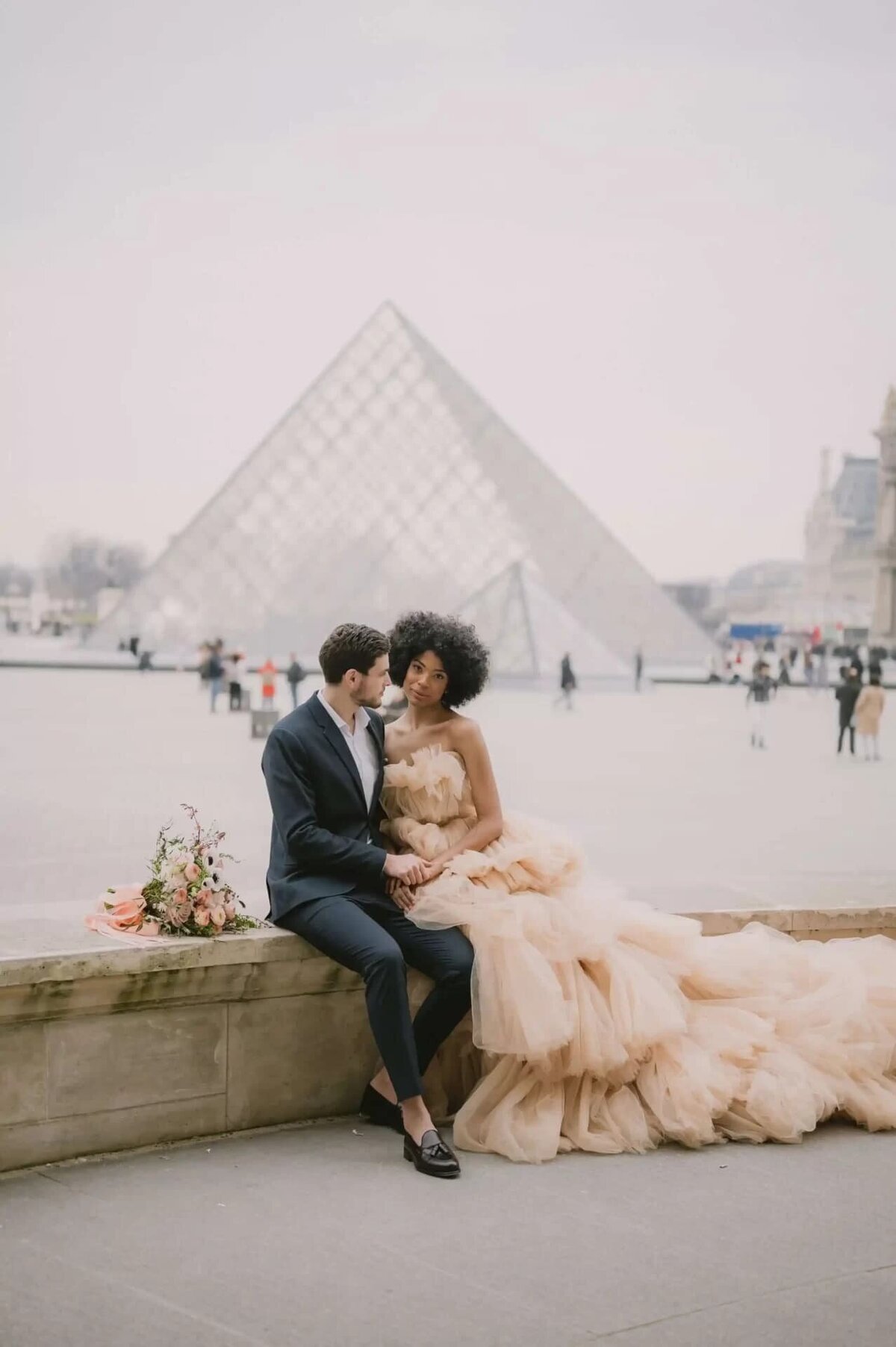 a couple having a photoshoot at the Louvre, in Paris