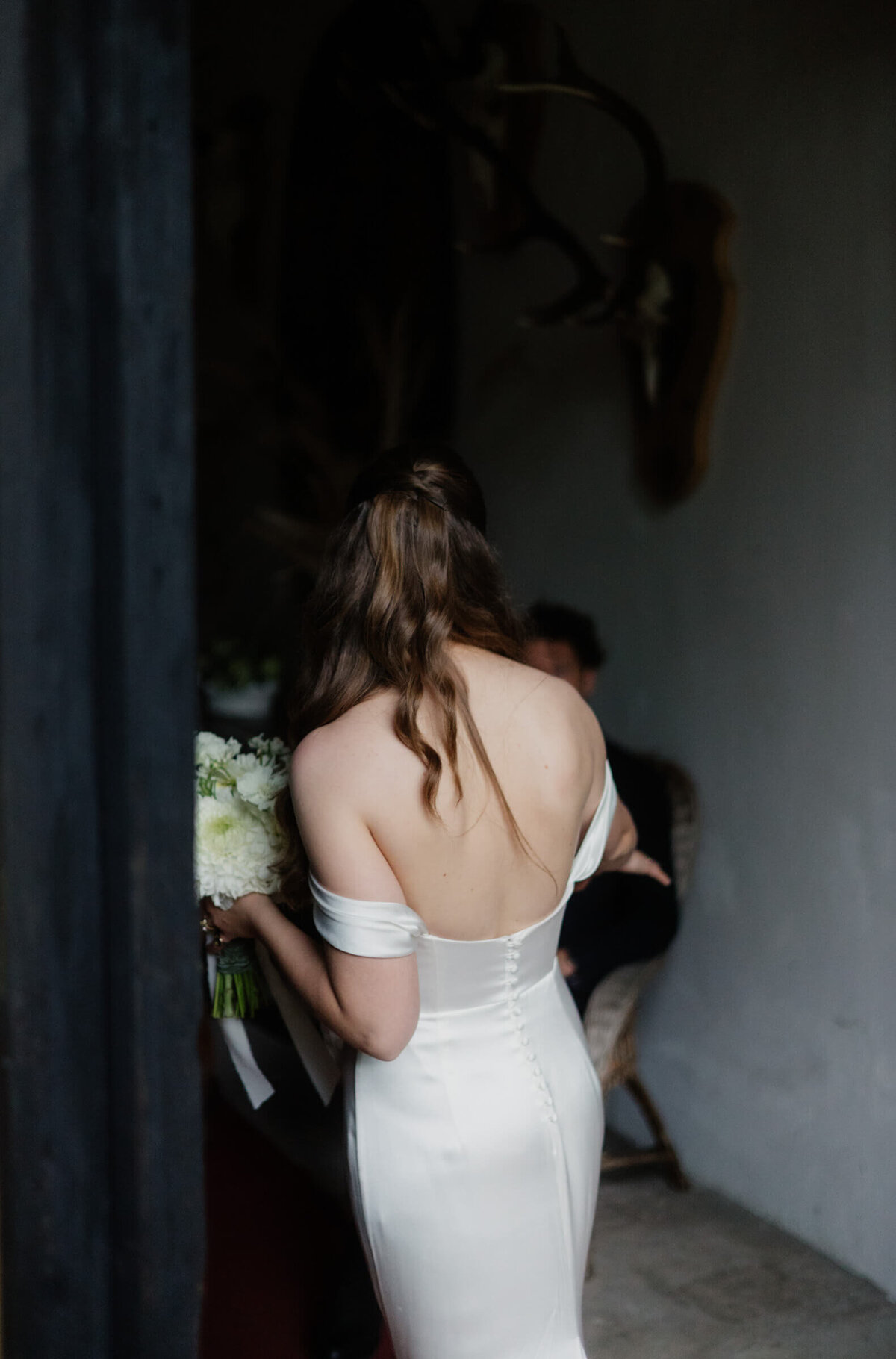 Braut tritt durch Tür – eleganter Moment bei einer Hochzeit im Palast Hohenems.

