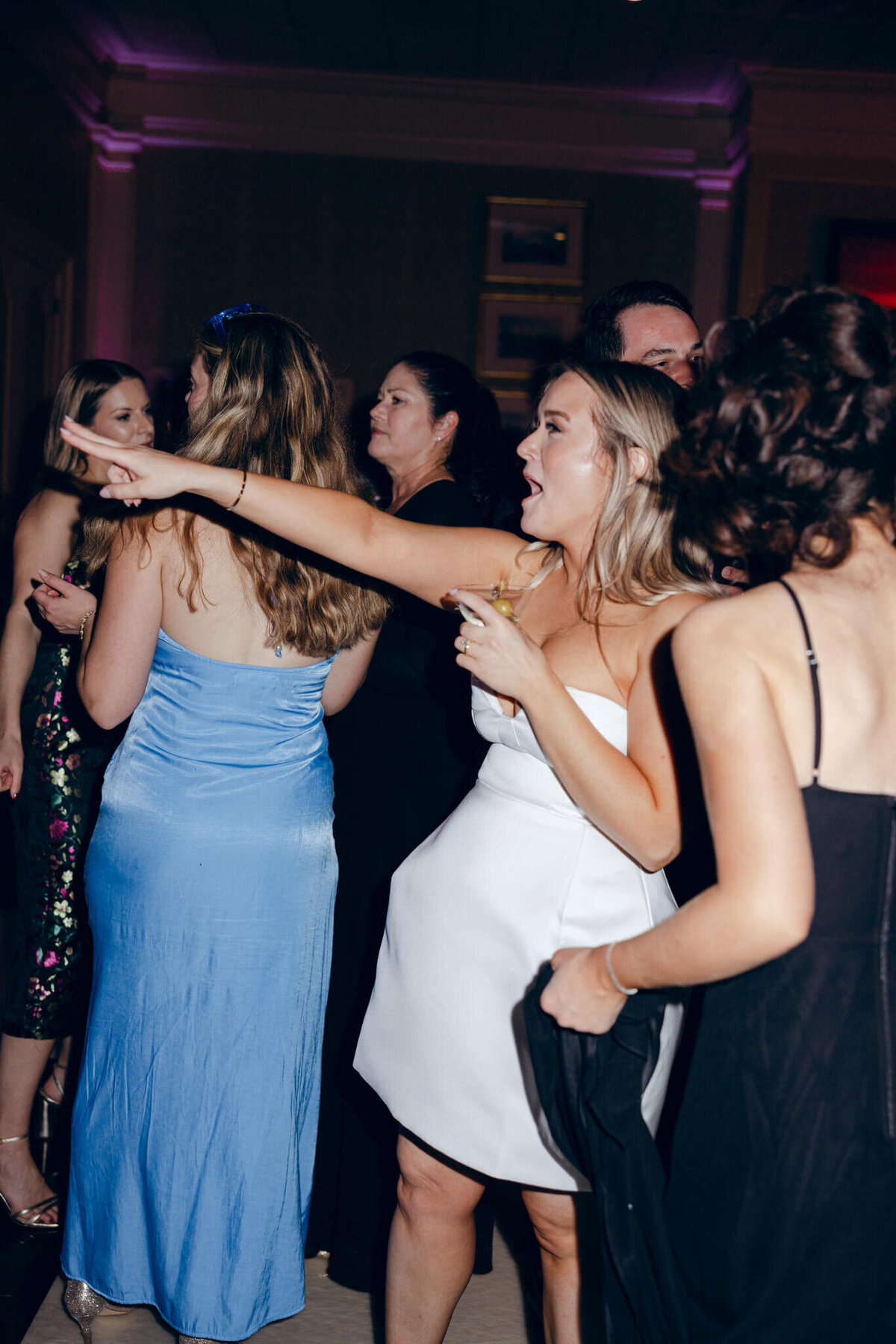 A wedding photo of guests dancing during the wedding reception