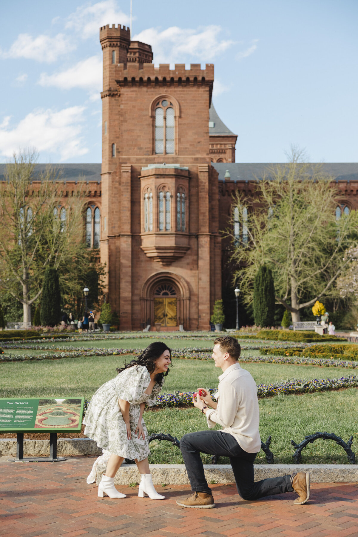 A proposal between a happy couple in front of Smithsonian Couple.